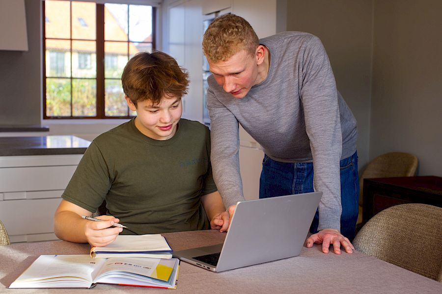 Mentor forklarer matematiske formler til eleven sin og hjelper ham på vei.