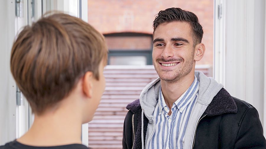 Mentor smiler til eleven sin før matematikkundervisningen deres.