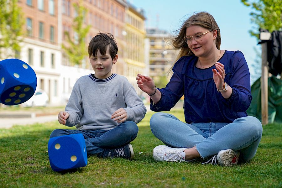 Mentor og elev kaster terninger i privatundervisning i matematikk.