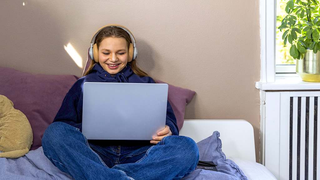 Online undervisning i Norsk, hvor eleven sidder og smiler