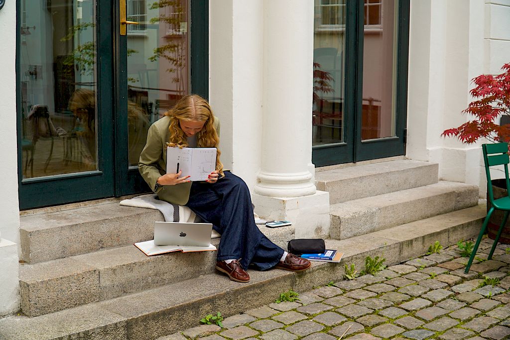 Mentor underviser på nett mens hun sitter utendørs.