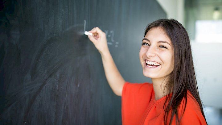 Glad elev viser matematiske beviser på en tavle