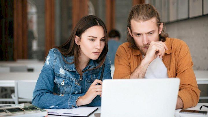 Mentor og elev sidder og kigger på computeren sammen