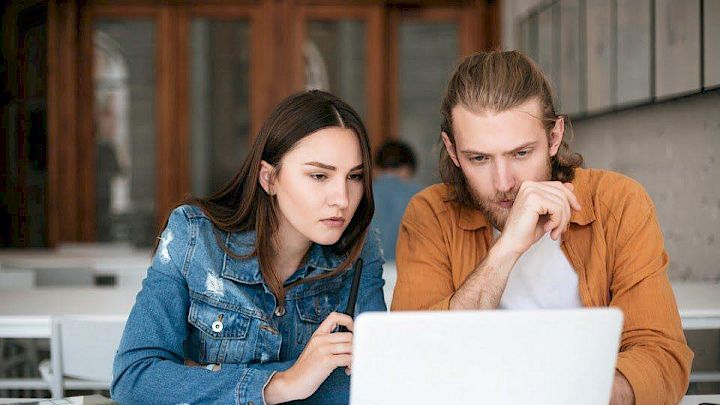 Mentor og elev sidder og kigger på computeren sammen