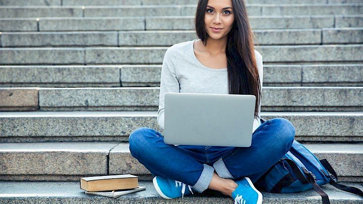 Elev sidder på trappe og har onlineundervisning