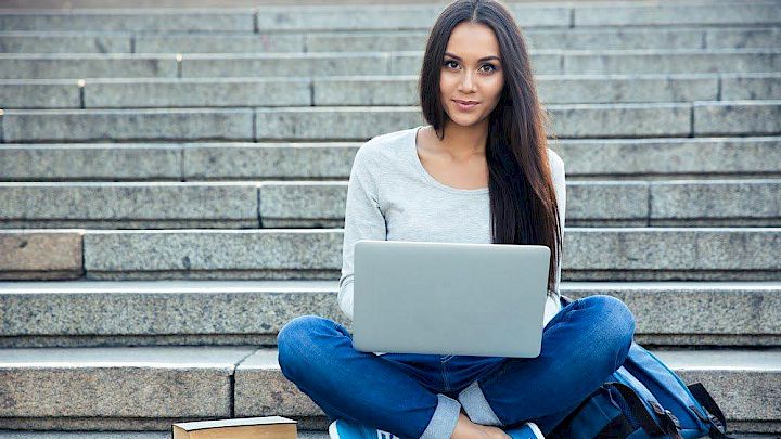 Elev sidder på trappe og har onlineundervisning