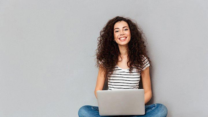 Glad elev sidder og forbereder opgaver på computer
