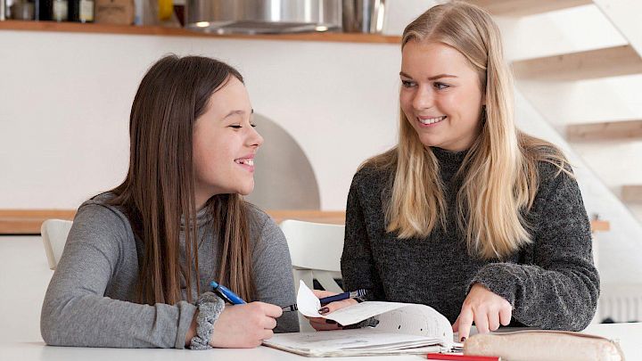 Kvindelig mentor og elev sidder og laver lektier