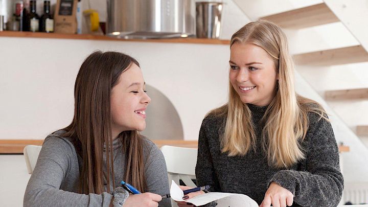 Kvindelig mentor og elev sidder og laver lektier
