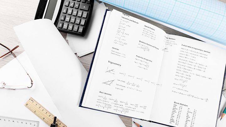 Illustration af elevs skrivebord med matematik redskaber