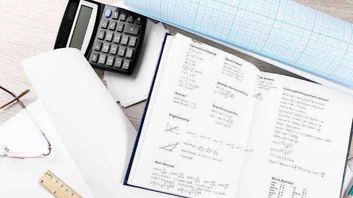 Illustration af elevs skrivebord med matematik redskaber