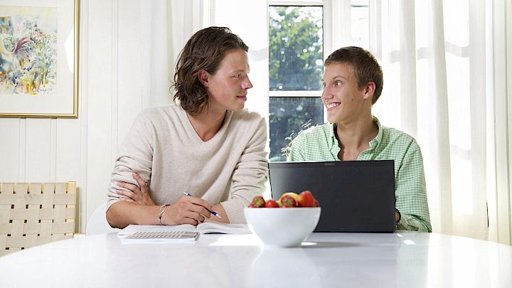 Elev sidder med sin mentor og får lektiehjælp