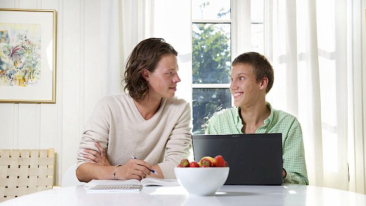 Elev sidder med sin mentor og får lektiehjælp