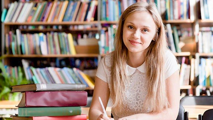 Elev der sidder på bibliotek og forbereder sin prøve