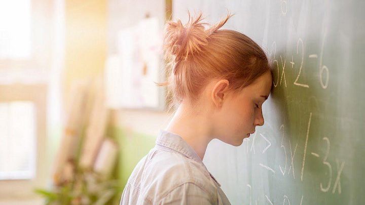 Elev der har hovedet mod tavlen i frustration