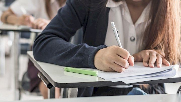 Elev der sider og skriver på opgave
