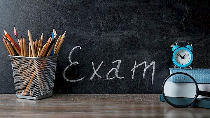 Kridttavle med eksamensreference og klassisk skoleudstyr