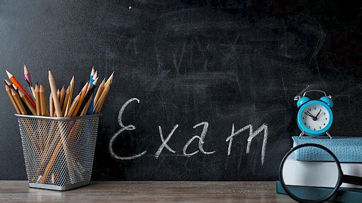 Kridttavle med eksamensreference og klassisk skoleudstyr