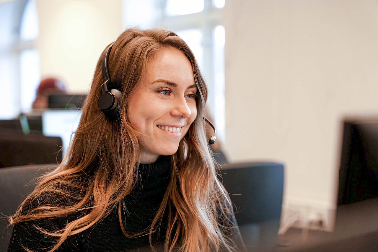 Fagveileder sitter og tar imot telefoner fra familier.
