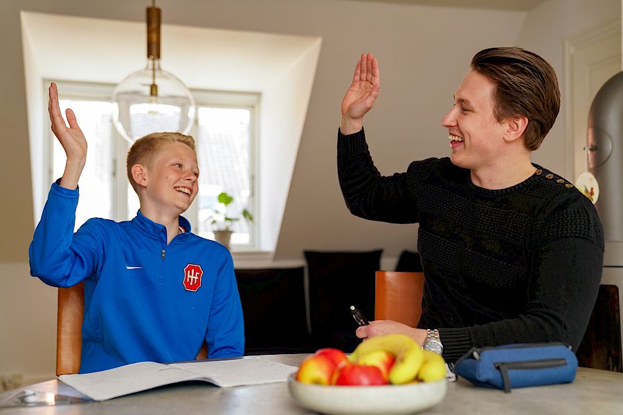 Mentor og elev gir high five etter at de løste en vanskelig oppgave i privatundervisningen.